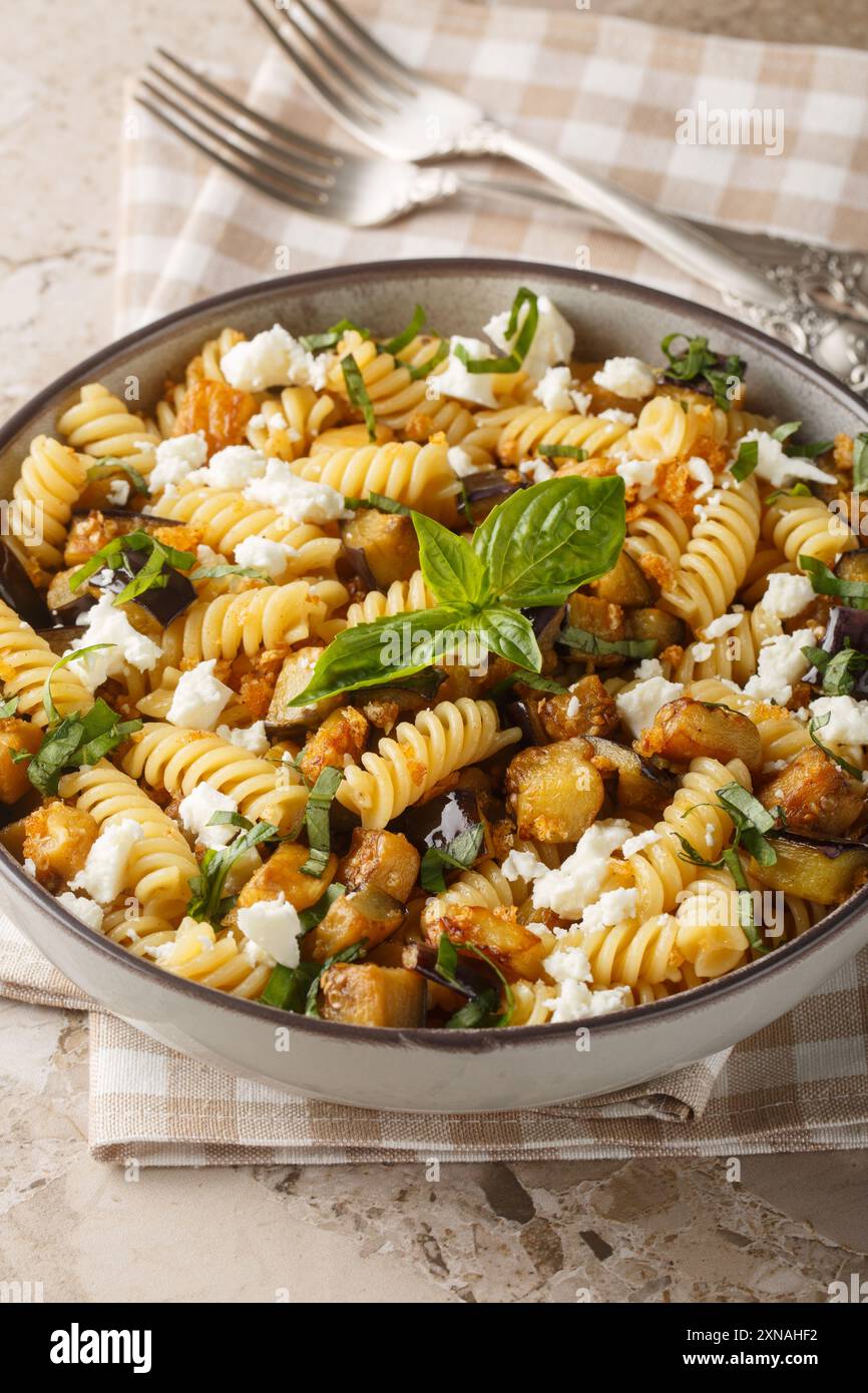 Pasta di melanzane Feta Garlicky con basilico e briciole di pane in primo piano sulla ciotola sul tavolo. Verticale Foto Stock