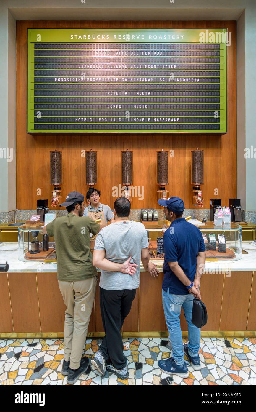 La gente parla con un barista all'interno della Starbucks Reserve Roastery, Milano, Italia Foto Stock