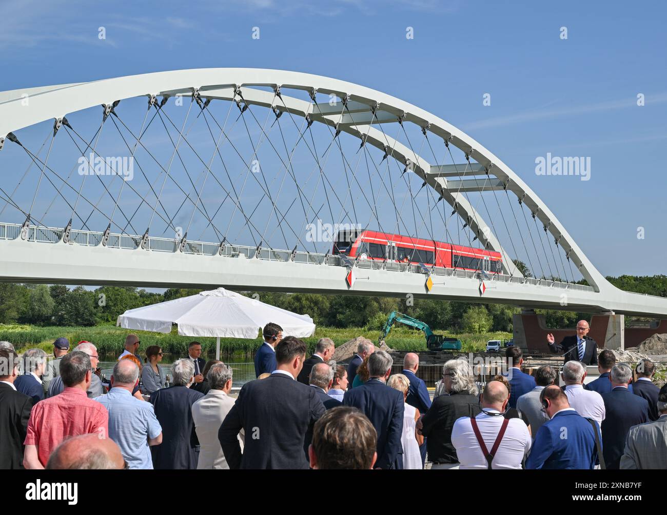 31 luglio 2024, Brandeburgo, Küstrin-Kietz: Dietmar Woidke (r, SPD), Ministro Presidente del Brandeburgo, interviene alla cerimonia di inaugurazione del nuovo ponte ferroviario sul fiume di confine Oder tra Kostrzyn in Polonia e Küstrin-Kietz sul lato tedesco. Niederbarnimer Eisenbahn gestisce il collegamento con la RB26 per conto degli stati di Brandeburgo e Berlino nell’ambito della rete del Brandeburgo orientale. La nuova struttura a ponte lunga 260 metri sull'Oder, il primo ponte ad arco al mondo con grucce in carbonio, può essere guidata su due binari a velocità fino a 120 chilometri all'ora. Foto Stock