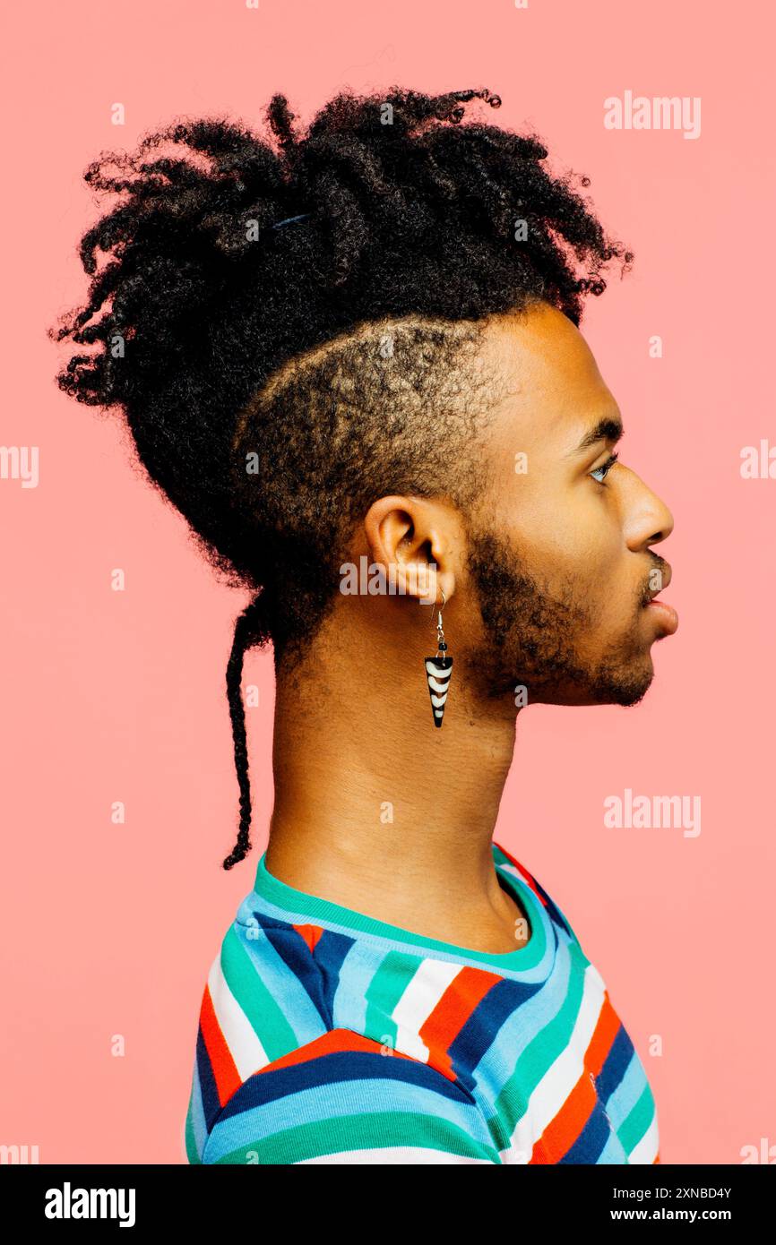Profilo di un uomo afroamericano sicuro ed elegante con un atteggiamento cool. Giovane uomo nero con un'acconciatura intrecciata alla moda Foto Stock