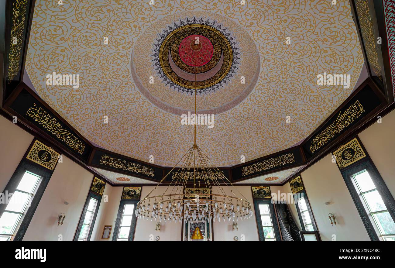 Soffitto con un enorme lampadario in una moschea. Foto Stock