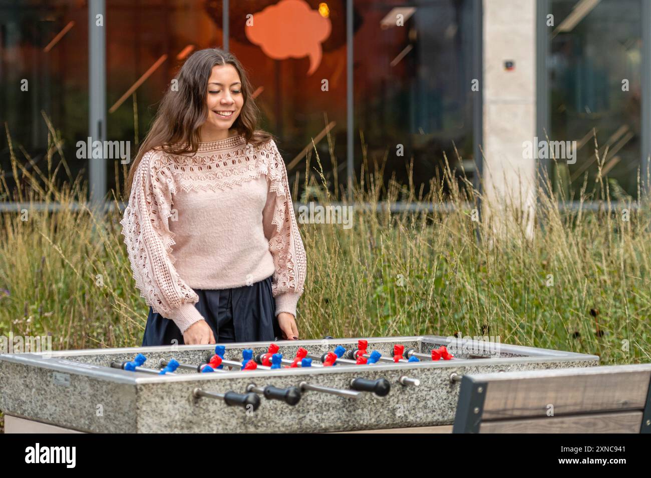 Una donna è felicemente impegnata in una partita di calcio all'aperto. Foto Stock