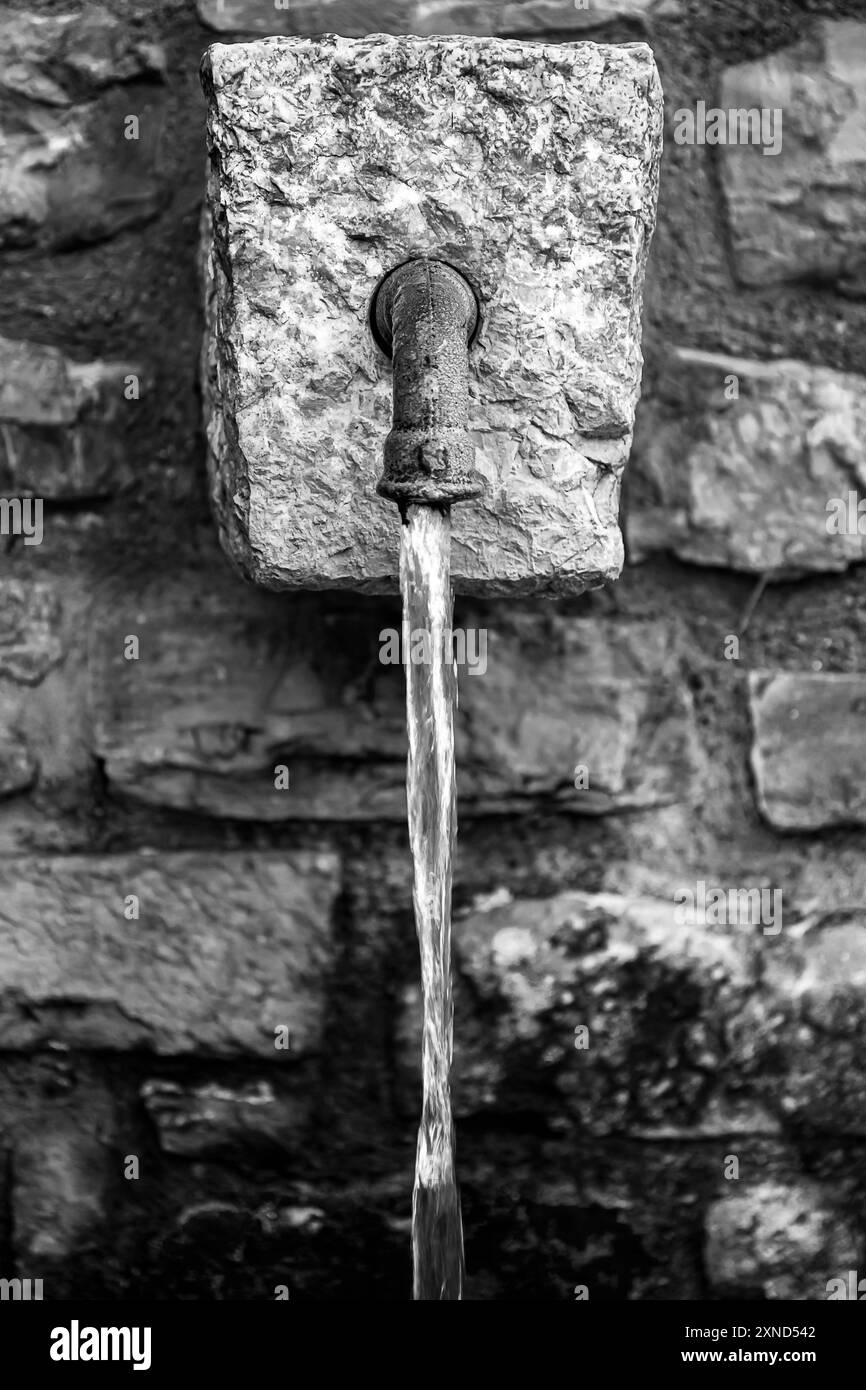 una fontana sgorga acqua fresca di montagna Foto Stock