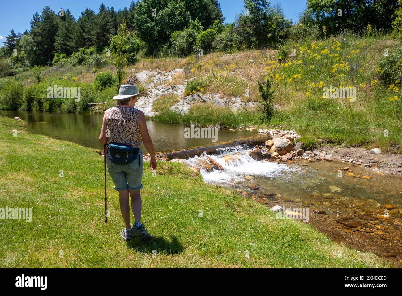 Donna che cammina lungo il fiume spagnolo Riaza a Riaza nella provincia di Segovia, Castiglia e León Spagna Foto Stock