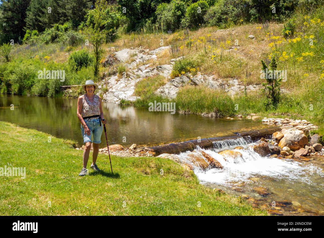 Donna che cammina lungo il fiume spagnolo Riaza a Riaza nella provincia di Segovia, Castiglia e León Spagna Foto Stock