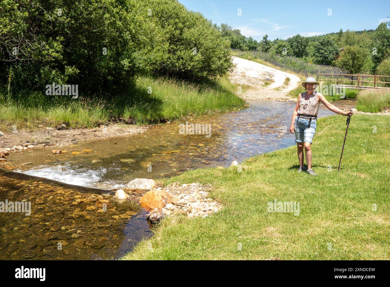 Donna che cammina lungo il fiume spagnolo Riaza a Riaza nella provincia di Segovia, Castiglia e León Spagna Foto Stock