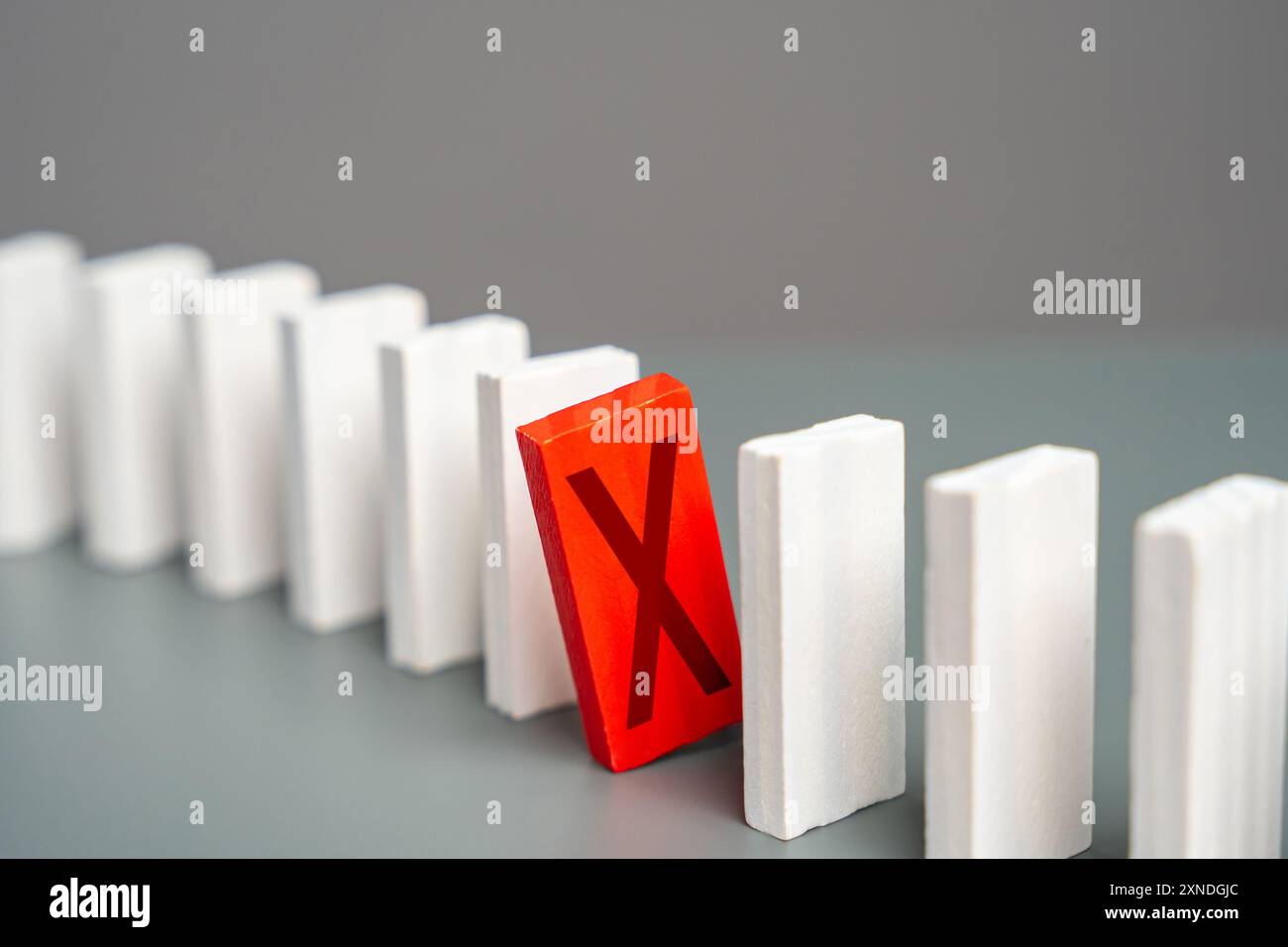 Il domino rosso con una croce ostacola l'intero processo. Guasto. Fuori servizio. Sanzioni. Interrompere il lavoro. Rifiuto e protesta. Errore critico. Non disponibile Foto Stock