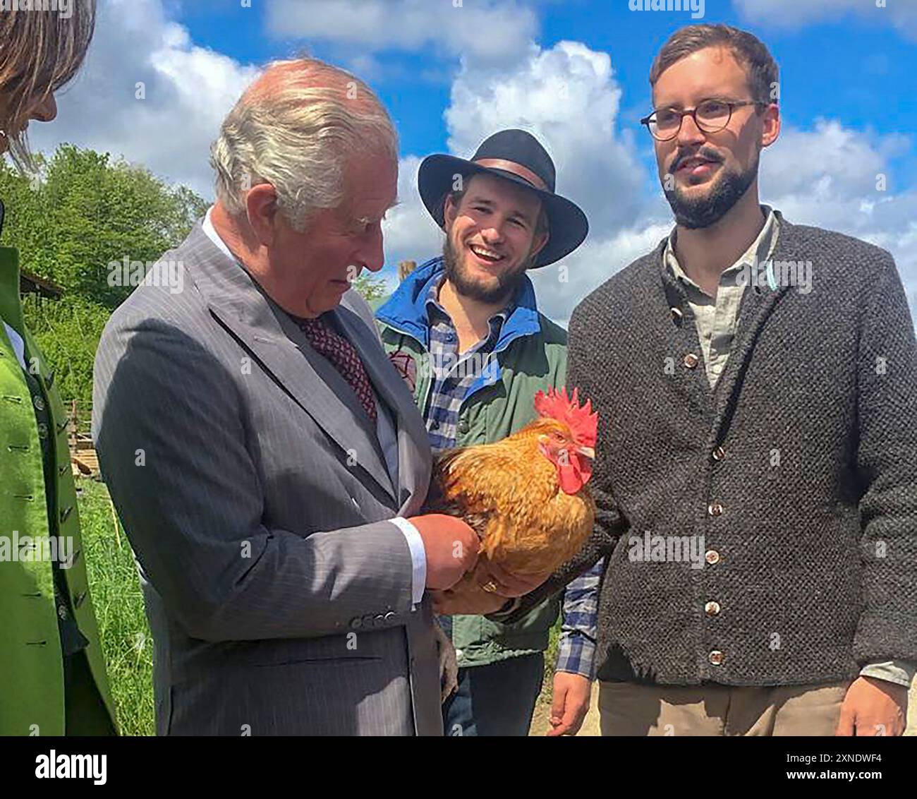 Il principe di Galles tiene un pollo durante una visita alla fattoria Herrmannsdorfer a Glonn, vicino a Monaco di Baviera in Germania. Foto Stock