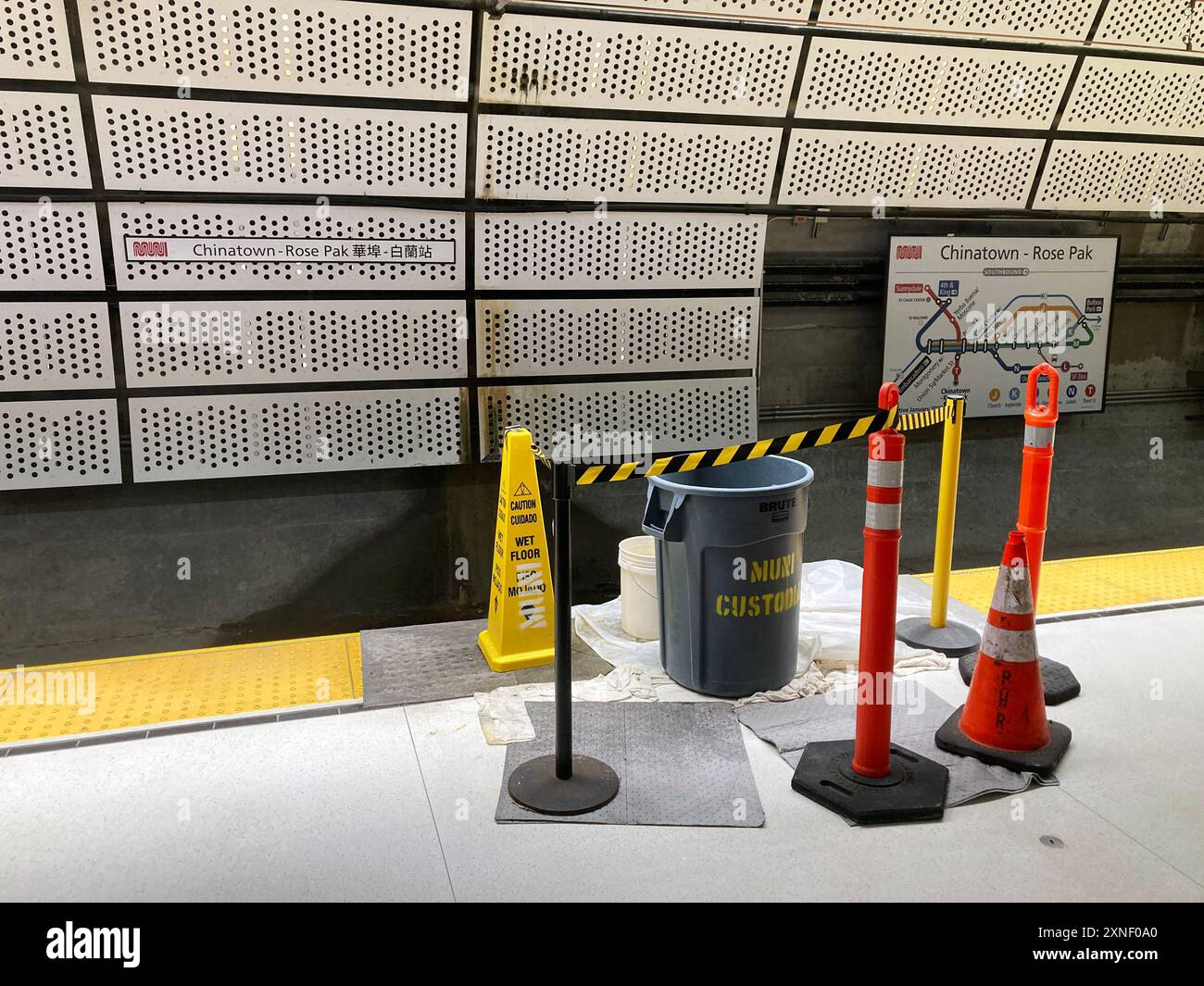 La sezione della piattaforma ferroviaria è bloccata a causa di infiltrazioni d'acqua alla stazione SF MUNI Chinatown-Rose Pak. I cartelli segnalano ai passeggeri il pavimento bagnato - San Franc Foto Stock