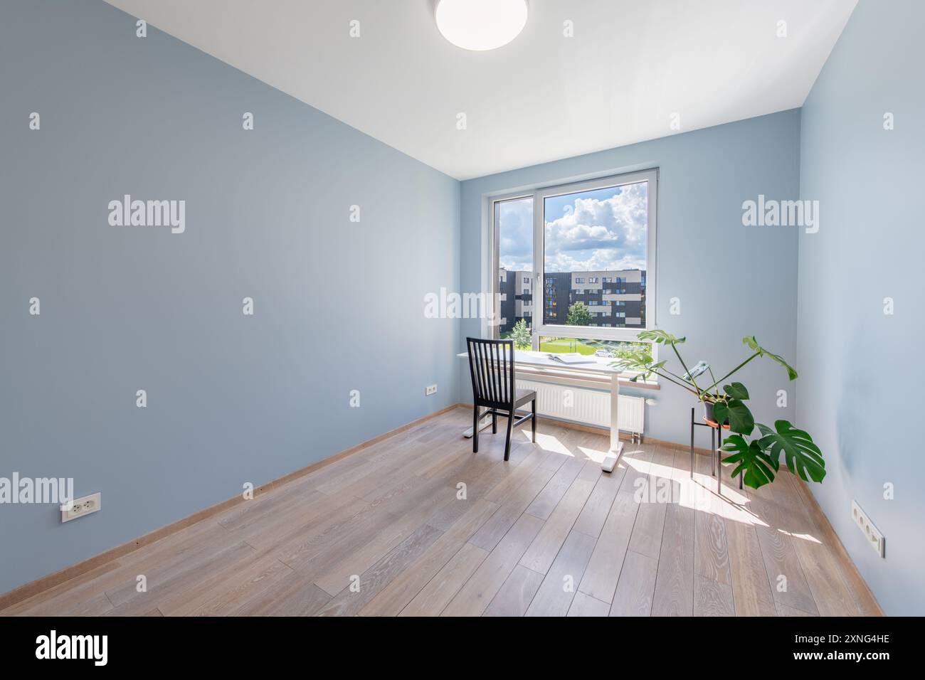 Interno del soggiorno di casa. Pavimento in legno, pareti di colore blu brillante, finestra. Tavolo e sedia nera. Guardaroba e porta sullo sfondo. Grandangolo Foto Stock