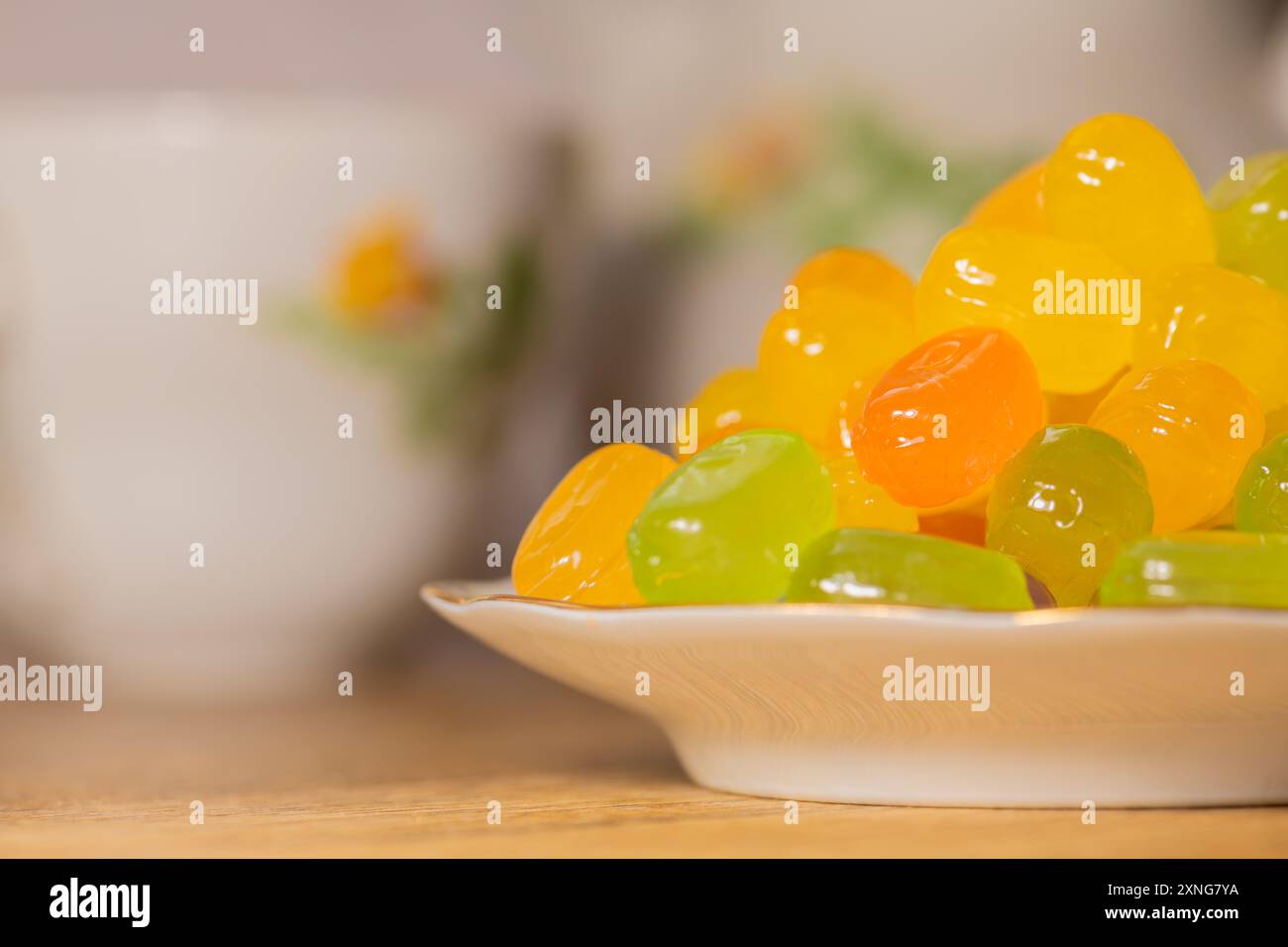 Caramelle dure colorate su un piattino. Piattino con caramelle dolci alla frutta colorata assortite su un tavolo di legno, primo piano, ad alta risoluzione. Foto Stock