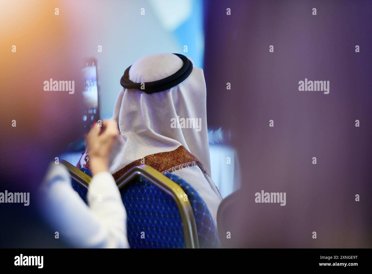 Uomini d'affari del Medio Oriente in abbigliamento tradizionale alla grande conferenza mondiale. Immagine del moderno mondo imprenditoriale e del concetto di investimento monetario Foto Stock