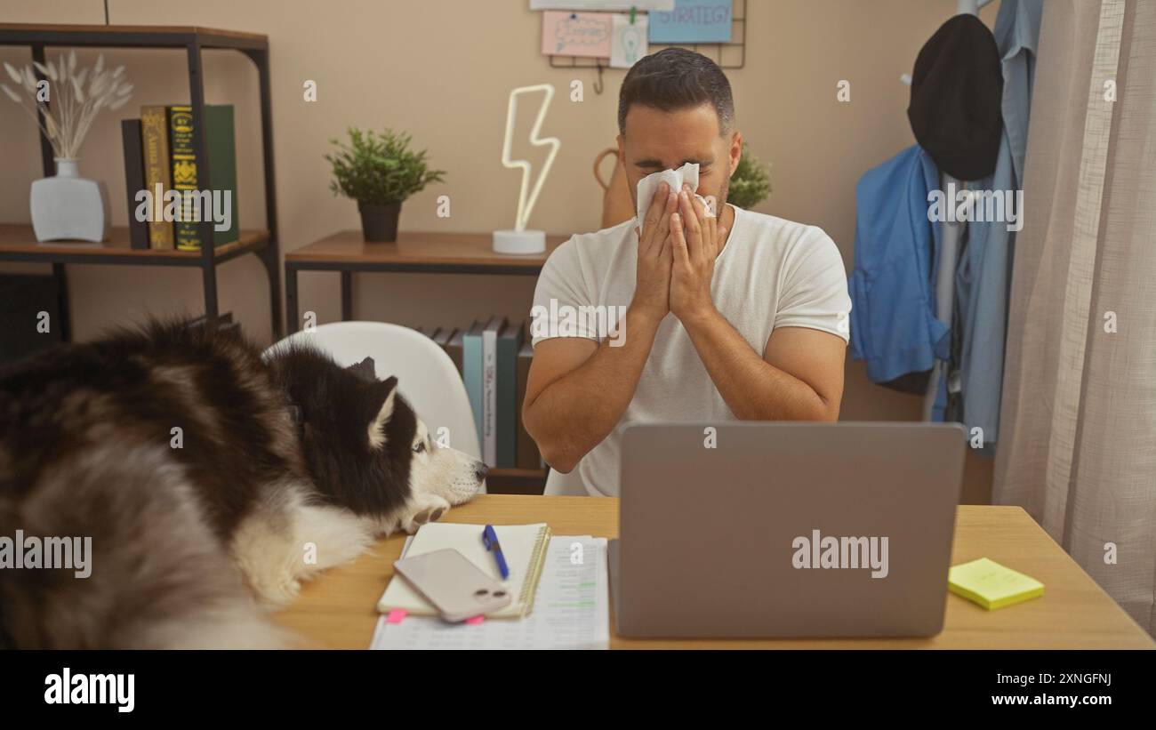 Un giovane starnuto accanto al suo husky in un ambiente ben organizzato da casa Foto Stock