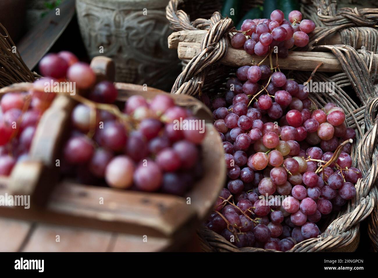 natura morta dell'uva e cesti rustici di vimini aria Foto Stock