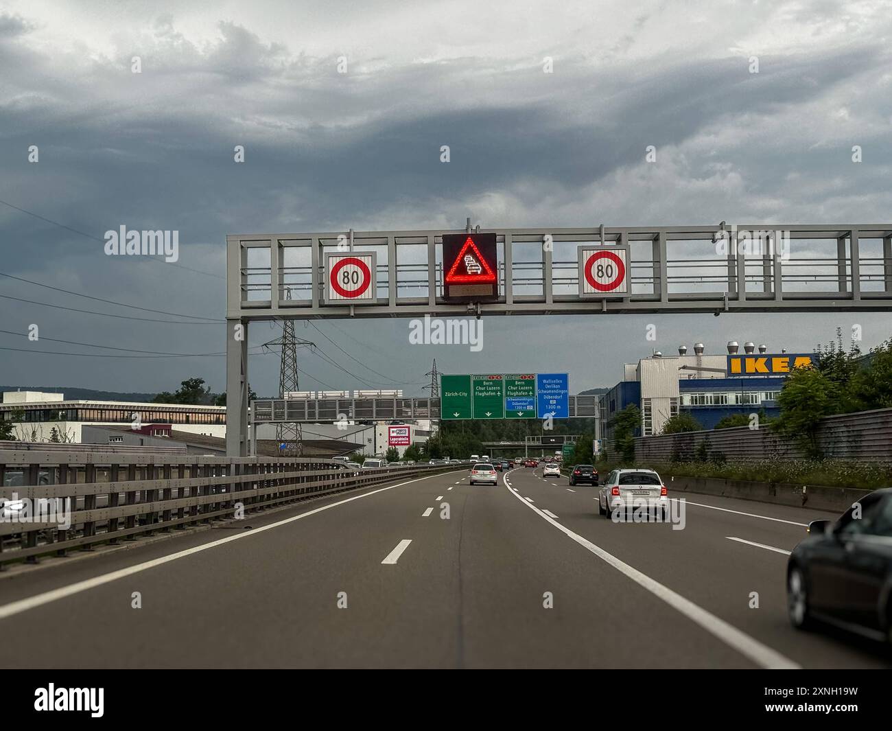 Autobahn, Verkehrsschilder, Zürich, Flughafen, Geschwindigkeitsbegrenzung, IKEA, Verkehrslage, Verkehrsfluss, Verkehrssicherheit, Straßennetz, Pendlerverkehr, Verkehrsinfrastruktur, Verkehrspolitik, VerkehrsInformation, Verkehrsüberwachung, Verkehrszeichen, Verkehrsdichte, Verkehrssteuerung, Mobilität, Reiseverkehr, Infrastruktur, Verkehrsmeldungen, Stau, Unfallgefahr, Verkehrsplanung, Verkehrsgeschehen, Gefahrensymbol, Verkehrshinweis, Digitales Verkehrsschild, LED-Anzeige. *** Superstrada, indicazioni stradali, Zurigo, aeroporto, limite di velocità, IKEA, situazione del traffico, flusso del traffico, sicurezza stradale, strada ne Foto Stock