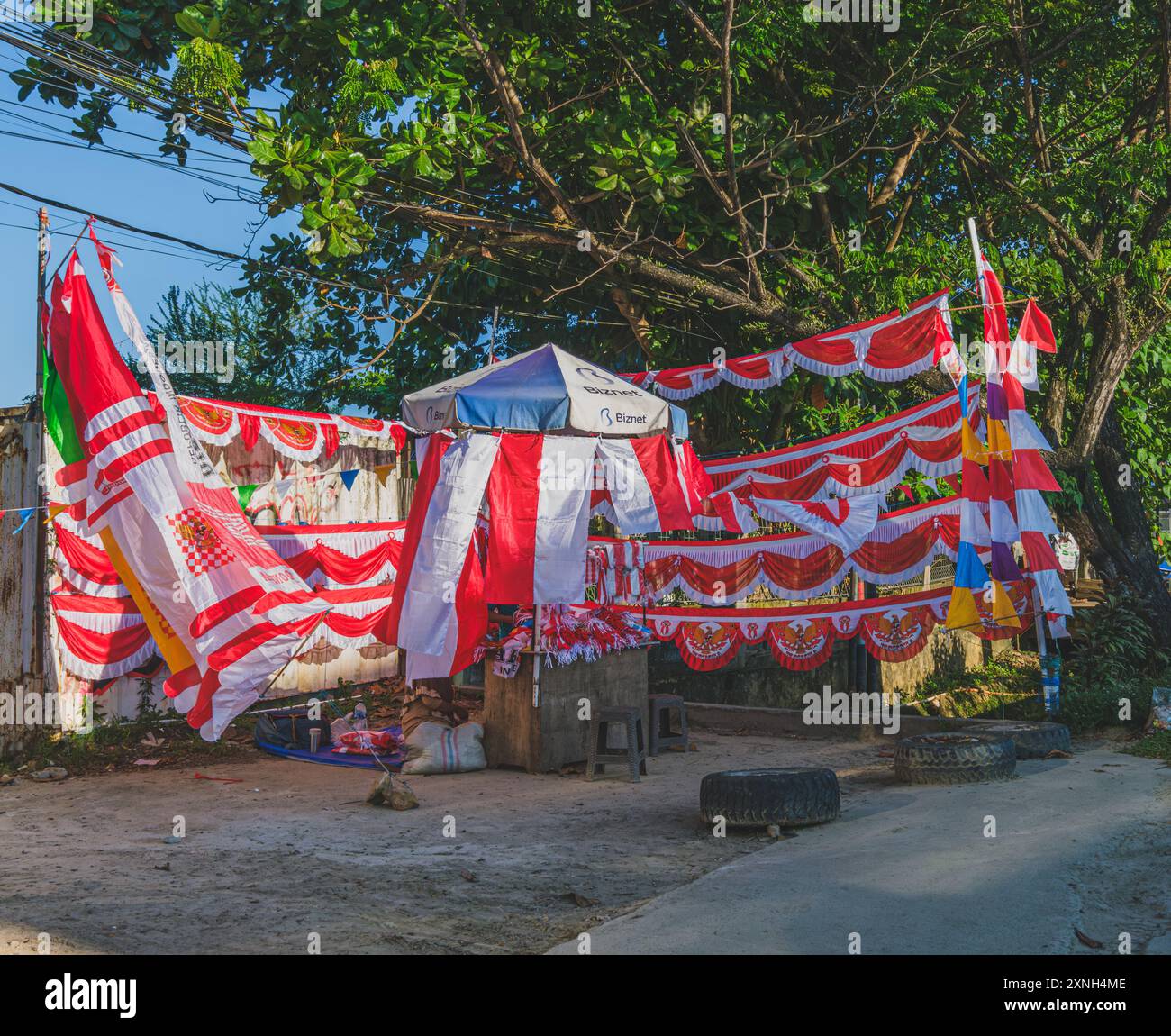 Balikpapan, Indonesia - 29 luglio 2024. Un venditore ambulante che mostra la colorata esposizione di bandiere e decorazioni indonesiane. Foto Stock