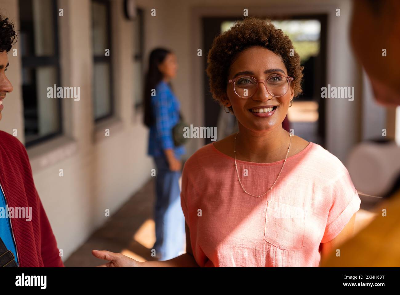 Parlare con gli amici, adolescente sorridente e socializzante alle superiori Foto Stock