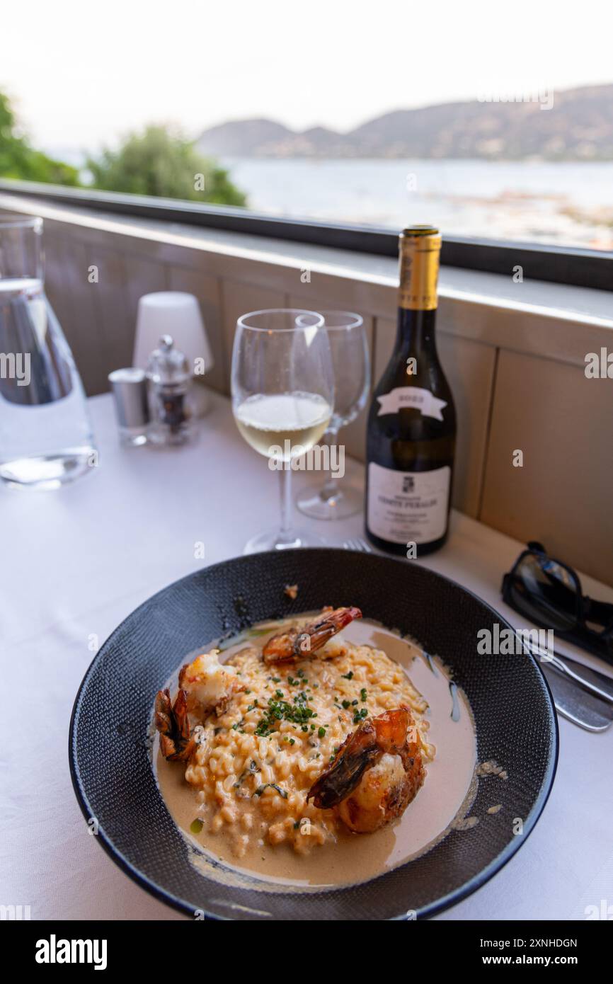 Risotto di gamberi grigliati con vino bianco all'aperto, Corsica estiva, Francia Foto Stock