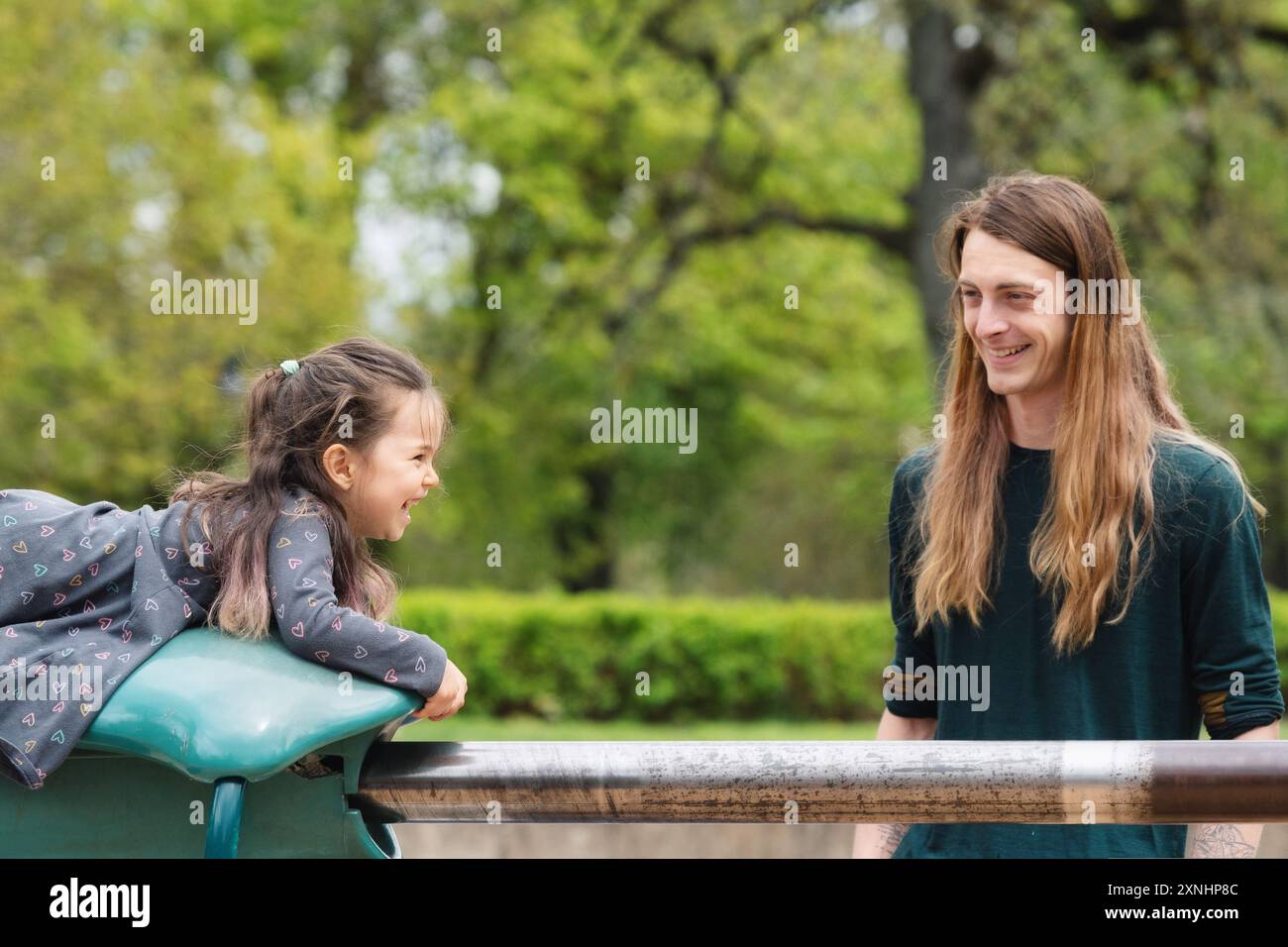 un padre e sua figlia giocano in un parco giochi Foto Stock