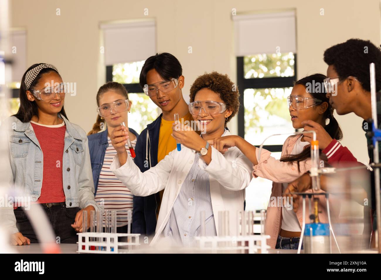 Condurre esperimenti scientifici con provette per test, studenti nel laboratorio delle scuole superiori Foto Stock