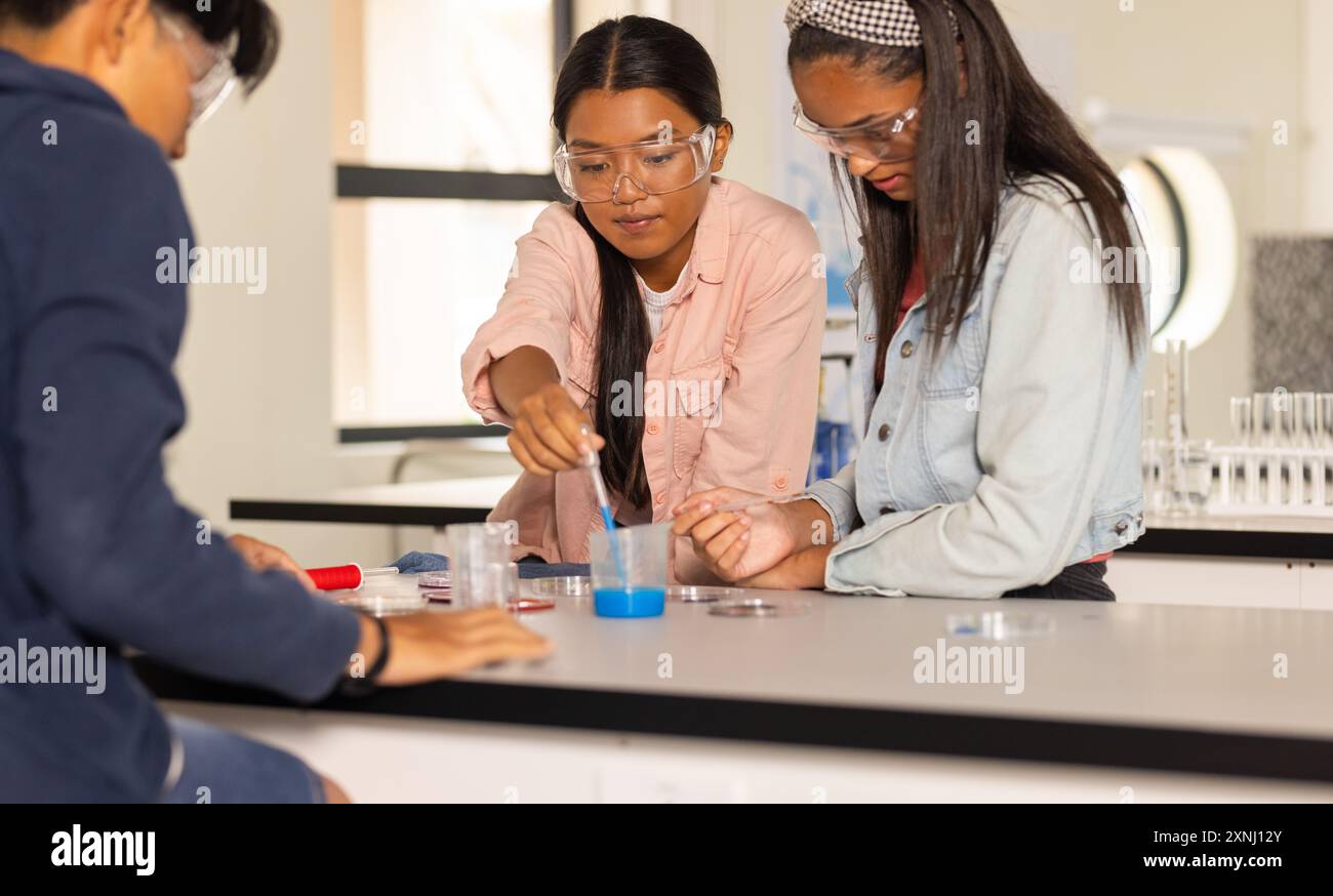 Al liceo, gli adolescenti che conducono esperimenti scientifici con occhiali di sicurezza in classe Foto Stock