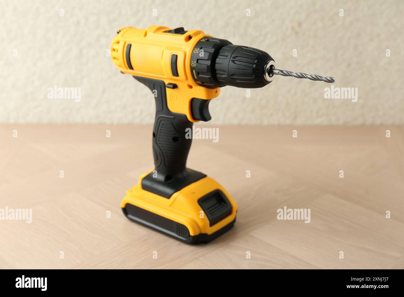 Un trapano elettrico a batteria su una superficie in legno Foto Stock