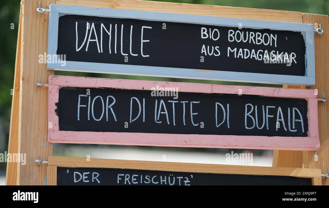 Un menu di gelati scritto in lingua italiana è scritto su una tavola di legno dal venditore di gelati Foto Stock