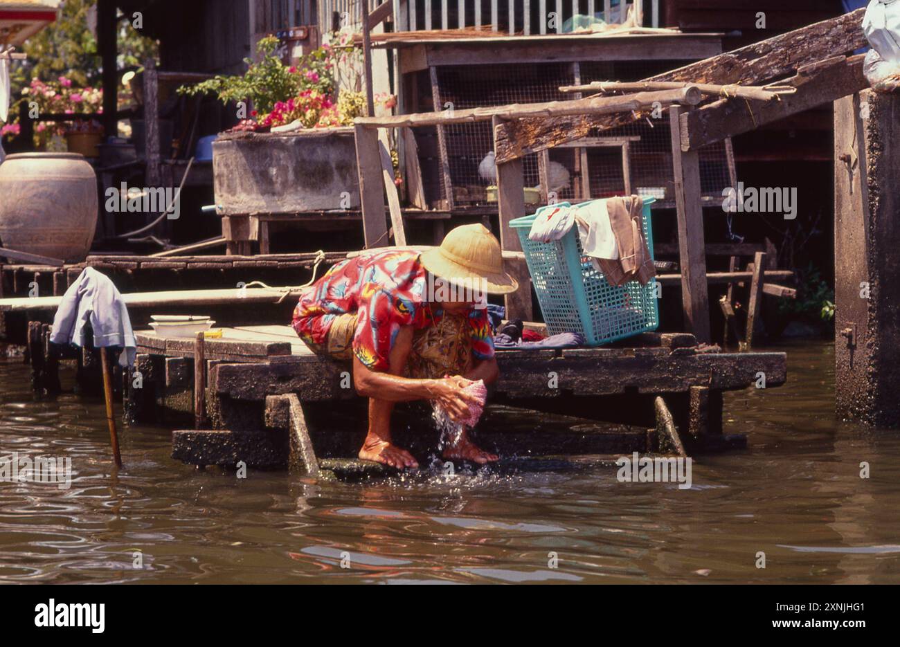 Donna thailandese che lava vestiti in un canale di Bangkok nel sud dei Klongs, Bangkok, Thailandia Foto Stock