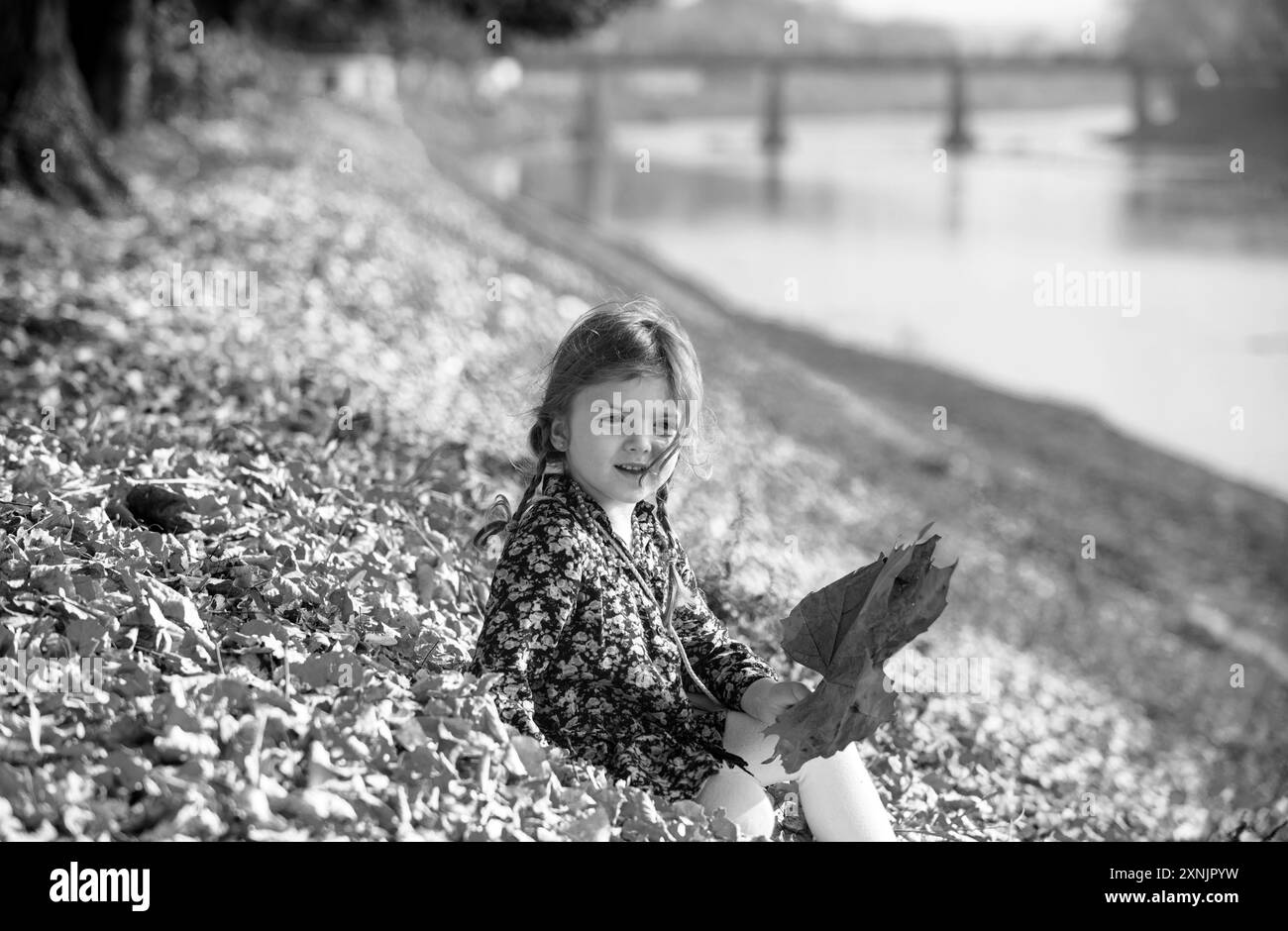 Bella autunno tempo in natura. I bambini giocano all'aperto. Bambina che gioca con foglie autunnali. Foto Stock
