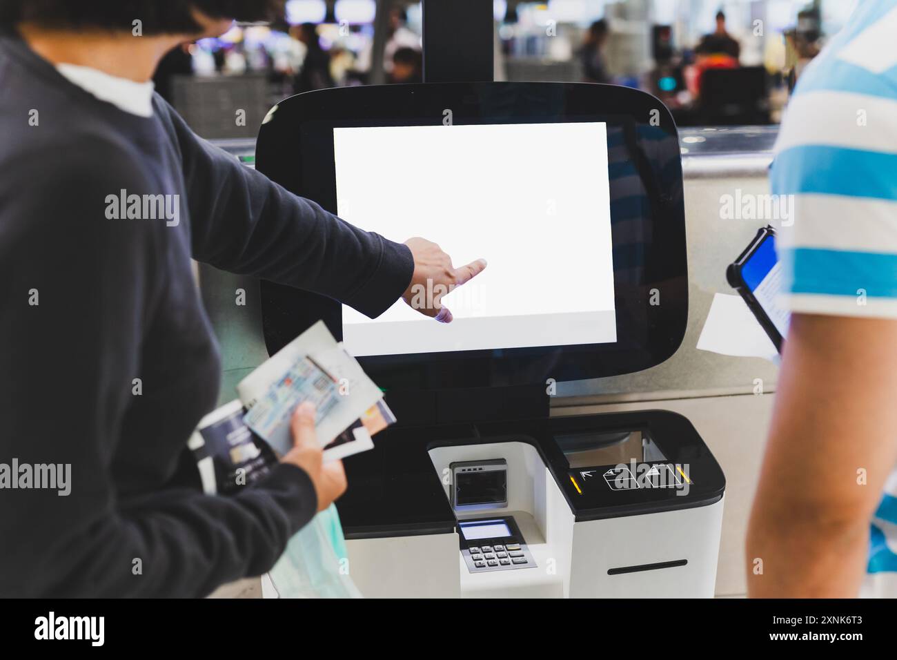 La coppia di passeggeri effettua il check-in self-service presso l'aeroporto internazionale. Foto Stock