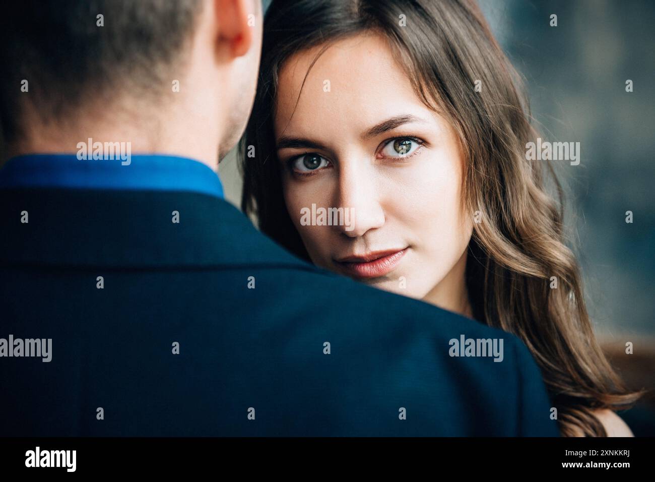 la ragazza abbraccia il ragazzo e guarda dritto nella cornice Foto Stock