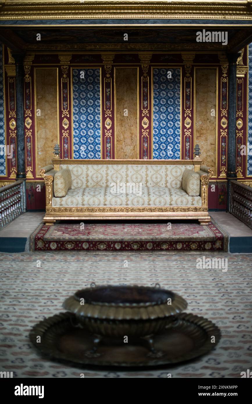 Palazzo Topkapi Harem Trono Imperiale Istanbul // ISTANBUL, Turchia — il trono imperiale ornato nella Hünkar Sofası (sala del Trono Imperiale) dell'Harem del Palazzo Topkapi, Istanbul. Questa sede riccamente decorata, adornata con metalli preziosi, pietre preziose e intricata artigianato, servì come fulcro per il pubblico privato del Sultano ottomano all'interno degli isolati confini dell'harem imperiale. Il trono simboleggia l'opulenza e l'autorità dell'Impero Ottomano, riflettendo la maestria artistica e il patrimonio culturale del periodo. Foto Stock