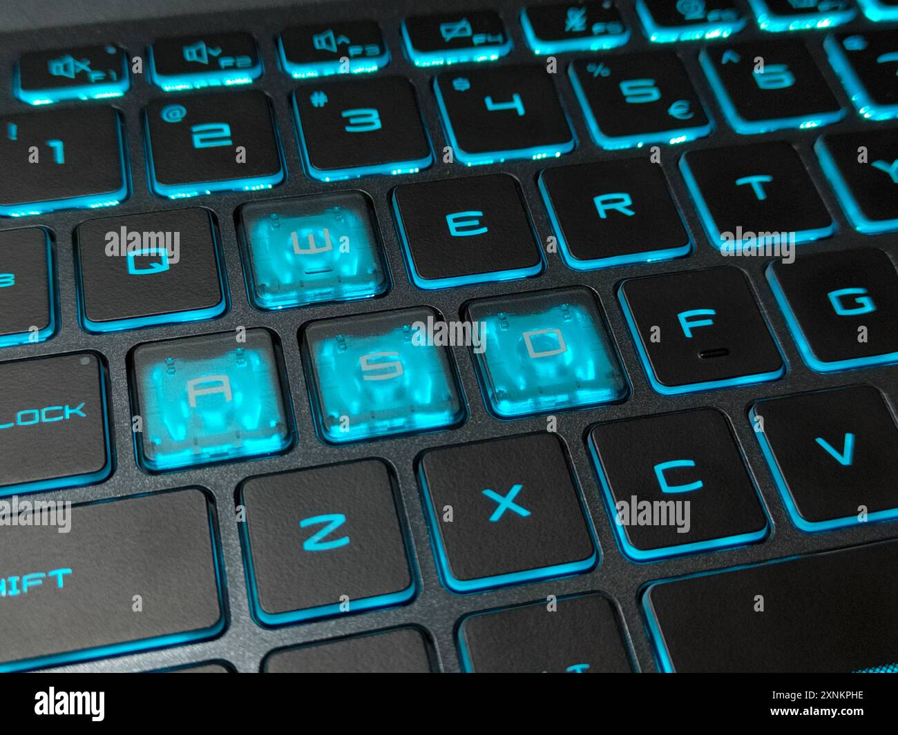 Primo piano di una tastiera RGB retroilluminata di colore blu su un laptop per giochi. Immagine con messa a fuoco selettiva Foto Stock