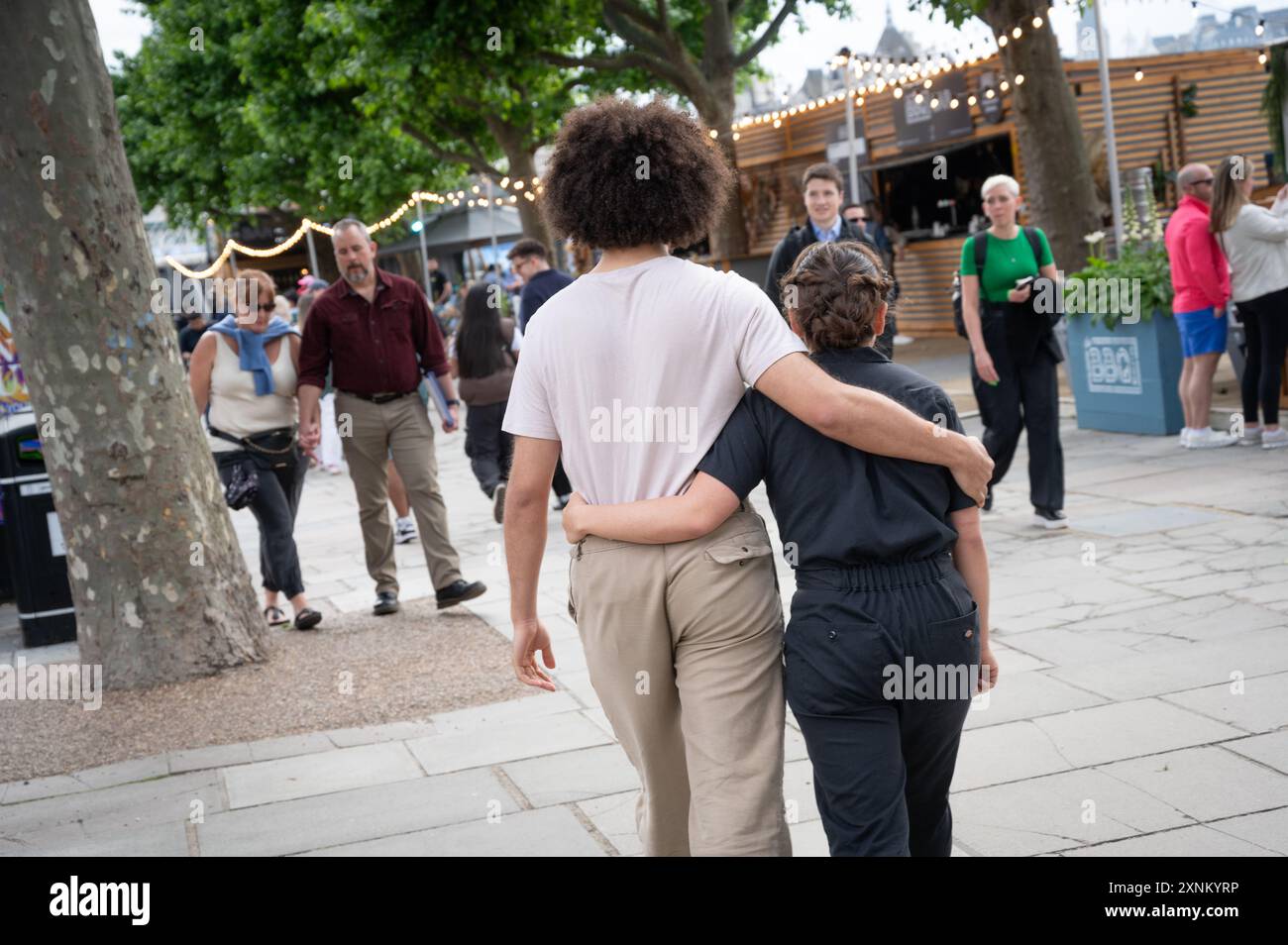 Una giovane coppia cammina lungo la South Bank a Londra braccio in braccio Foto Stock
