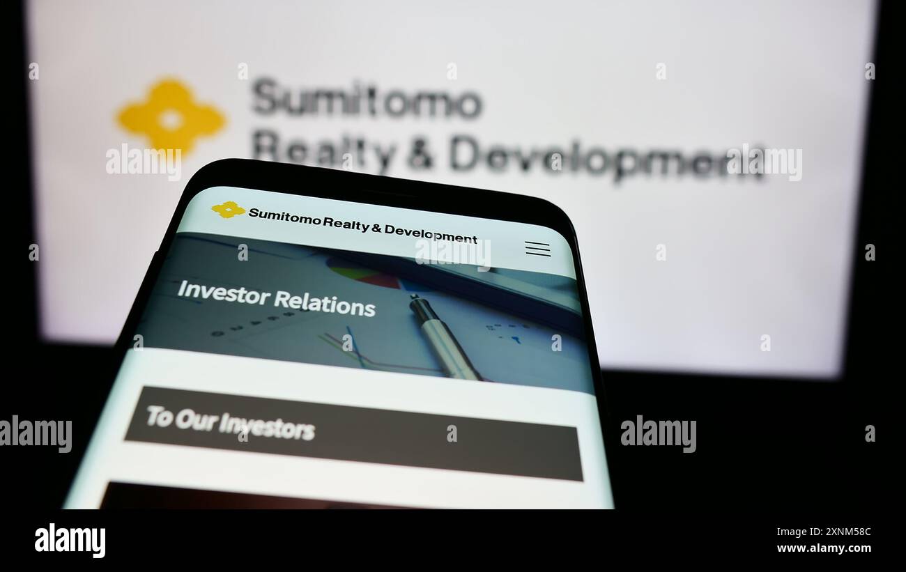 Smartphone con sito Web dell'ocmpany giapponese Sumitomo Realty Development Co. Ltd. Davanti al logo aziendale. Mettere a fuoco in alto a sinistra sul display del telefono. Foto Stock