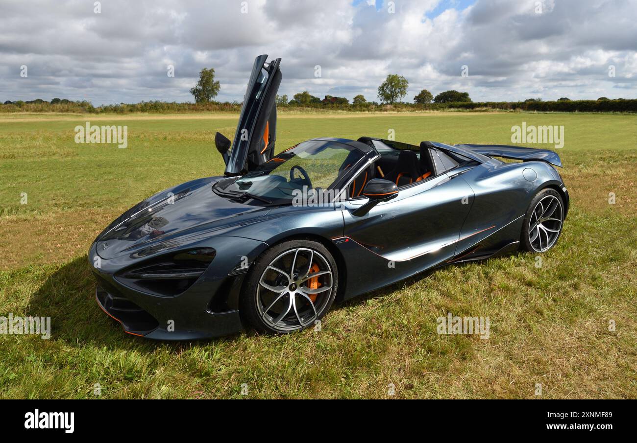 Auto nera della McLaren 720s con porta aperta isolata sul campo. Foto Stock