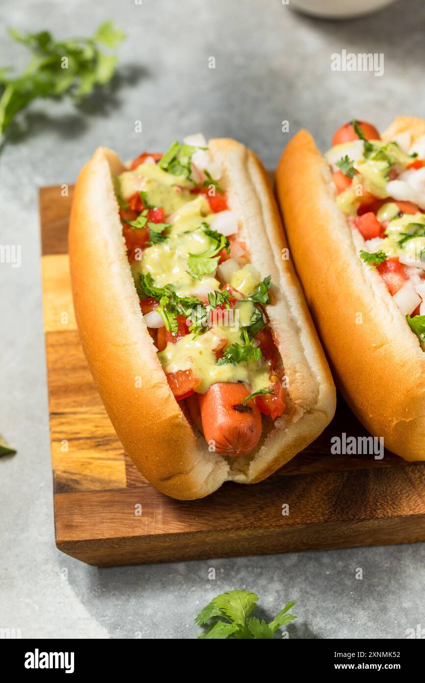 Piccanti cani caldi messicani fatti in casa con cipolla di coriandolo e salsa di avocado Foto Stock