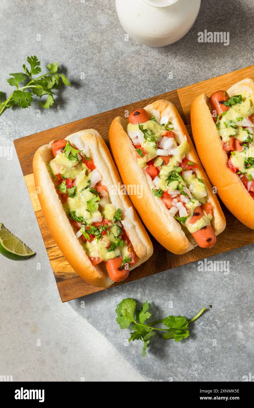 Piccanti cani caldi messicani fatti in casa con cipolla di coriandolo e salsa di avocado Foto Stock