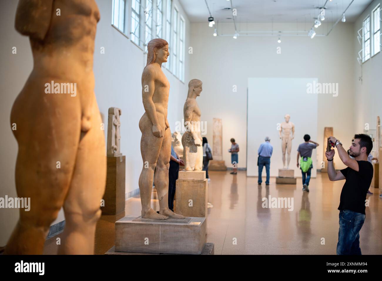 Museo Archeologico Nazionale statue di Kouros Atene // ATENE, Grecia - il Museo Archeologico Nazionale di Atene ospita una vasta gamma di sculture e statue, che rappresentano alcuni dei migliori esempi di arte greca antica. La collezione del museo copre diversi periodi storici, tra cui l'era arcaica, classica ed ellenistica, che mostrano l'evoluzione della scultura greca nel corso dei secoli. I visitatori possono ammirare opere iconiche come l'Afrodite di Arles e le statue di Kouros, che riflettono l'eccellenza artistica e il patrimonio culturale dell'antica Grecia. Foto Stock