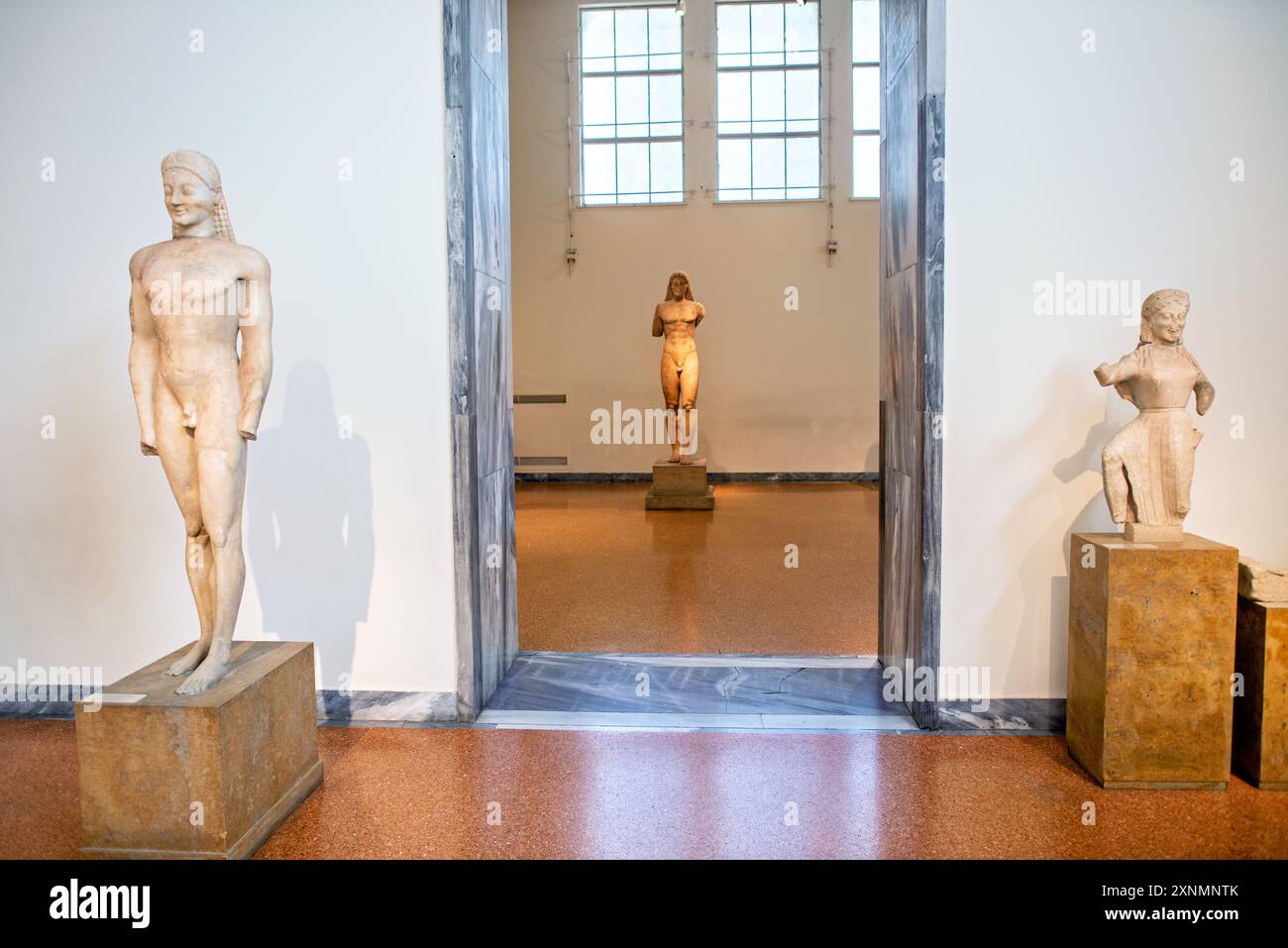 Museo Archeologico Nazionale statue di Kouros Atene // ATENE, Grecia - il Museo Archeologico Nazionale di Atene ospita una vasta gamma di sculture e statue, che rappresentano alcuni dei migliori esempi di arte greca antica. La collezione del museo copre diversi periodi storici, tra cui l'era arcaica, classica ed ellenistica, che mostrano l'evoluzione della scultura greca nel corso dei secoli. I visitatori possono ammirare opere iconiche come l'Afrodite di Arles e le statue di Kouros, che riflettono l'eccellenza artistica e il patrimonio culturale dell'antica Grecia. Foto Stock