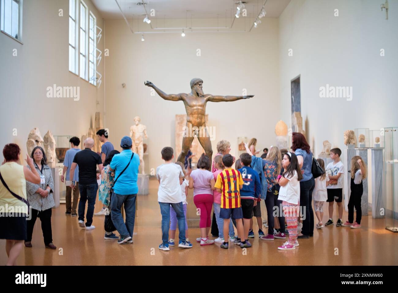 Zeus o statua in bronzo di Poseidone Museo Archeologico Nazionale Atene // ATENE, Grecia — la statua di Zeus o Poseidone, una suggestiva scultura in bronzo del V secolo a.C., è una delle più famose mostre al Museo Archeologico Nazionale di Atene. Si ritiene che questa iconica scultura, scoperta nel mare al largo di Capo Artemision, rappresenti Zeus, che regge un fulmine, o Poseidone, che brandisce un tridente. La statua è celebrata per la sua posa dinamica e l'intricata maestria artigianale, che esemplifica l'eccellenza artistica degli antichi scultori greci. Foto Stock