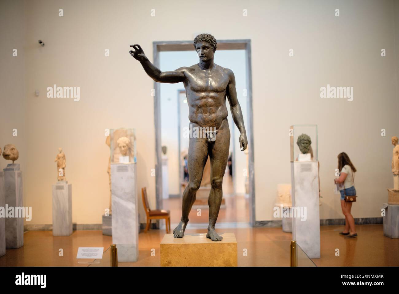 La statua di Antikythera Efebe Museo Archeologico Nazionale Atene // ATENE, Grecia — l'Efebo di Antikythera, noto anche come la Gioventù di Antikythera, è una scultura in bronzo esposta presso il Museo Archeologico Nazionale di Atene. Recuperata dal naufragio di Antikythera, questa statua risale alla fine del IV secolo a.C. e rappresenta una giovane figura maschile idealizzata, che mostra il significato artistico e culturale del periodo ellenistico. L'Antikythera Efebe è noto per la sua rappresentazione realistica e l'intricata artigianato, mettendo in evidenza l'eccellenza degli antichi scultori greci. Foto Stock