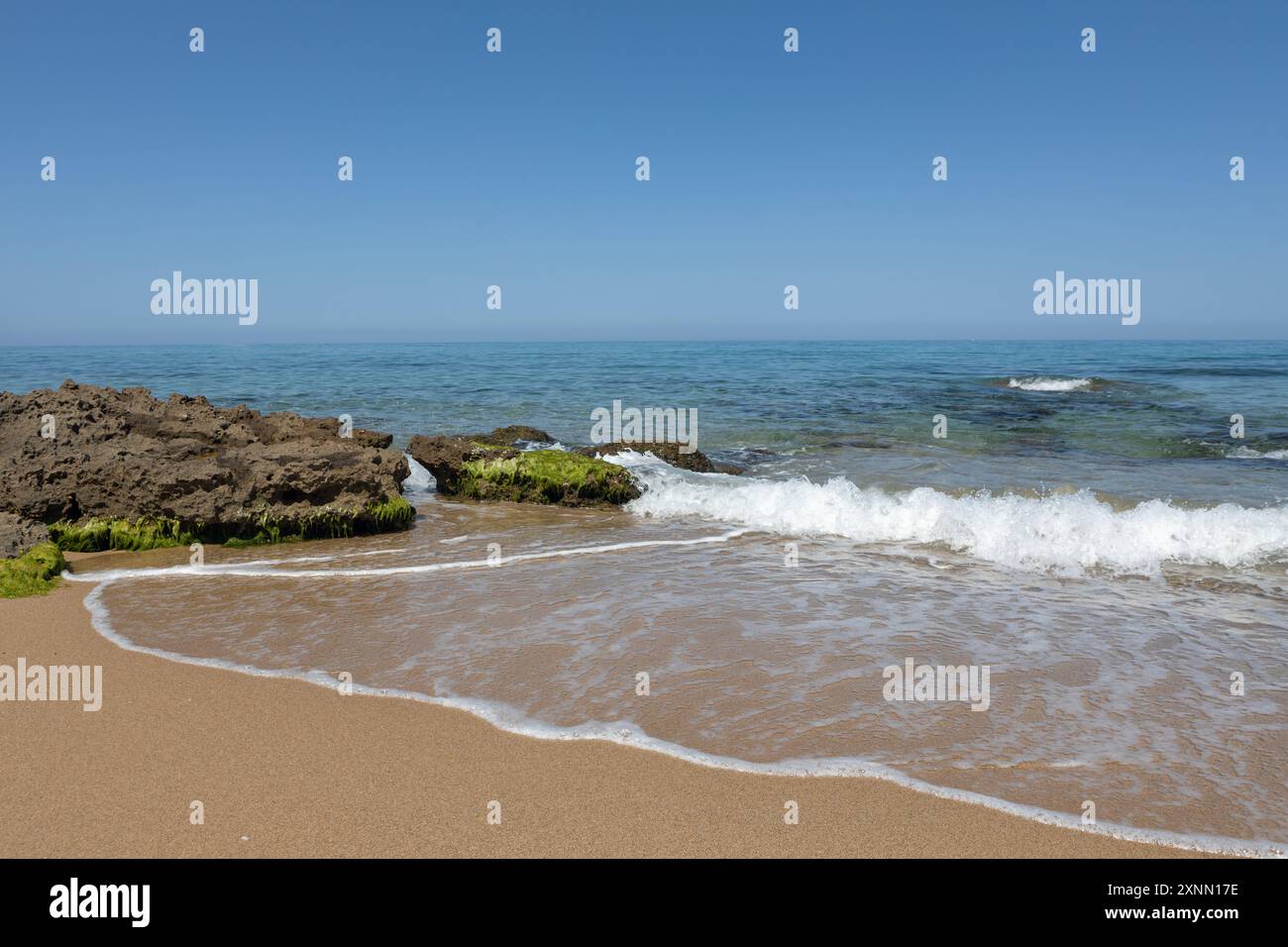 Spiaggia tranquilla con onde dolci Foto Stock
