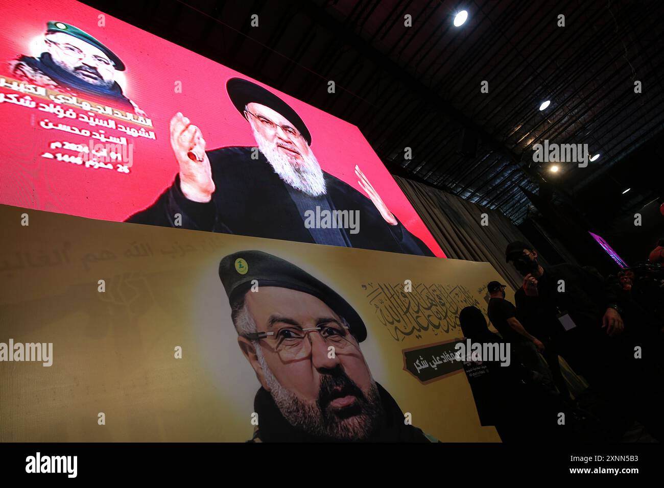 Beirut, Libano. 1 agosto 2024. Un discorso trasmesso in televisione dal capo Hezbollah, Hassan Nasrallah, viene trasmesso su grandi schermi durante il servizio funebre del comandante Fuad Shukr, nella periferia meridionale di Beirut. Shukr è stato ucciso in uno sciopero israeliano che ha anche causato la morte di cinque civili e decine di feriti. Crediti: Marwan Naamani/dpa/Alamy Live News Foto Stock