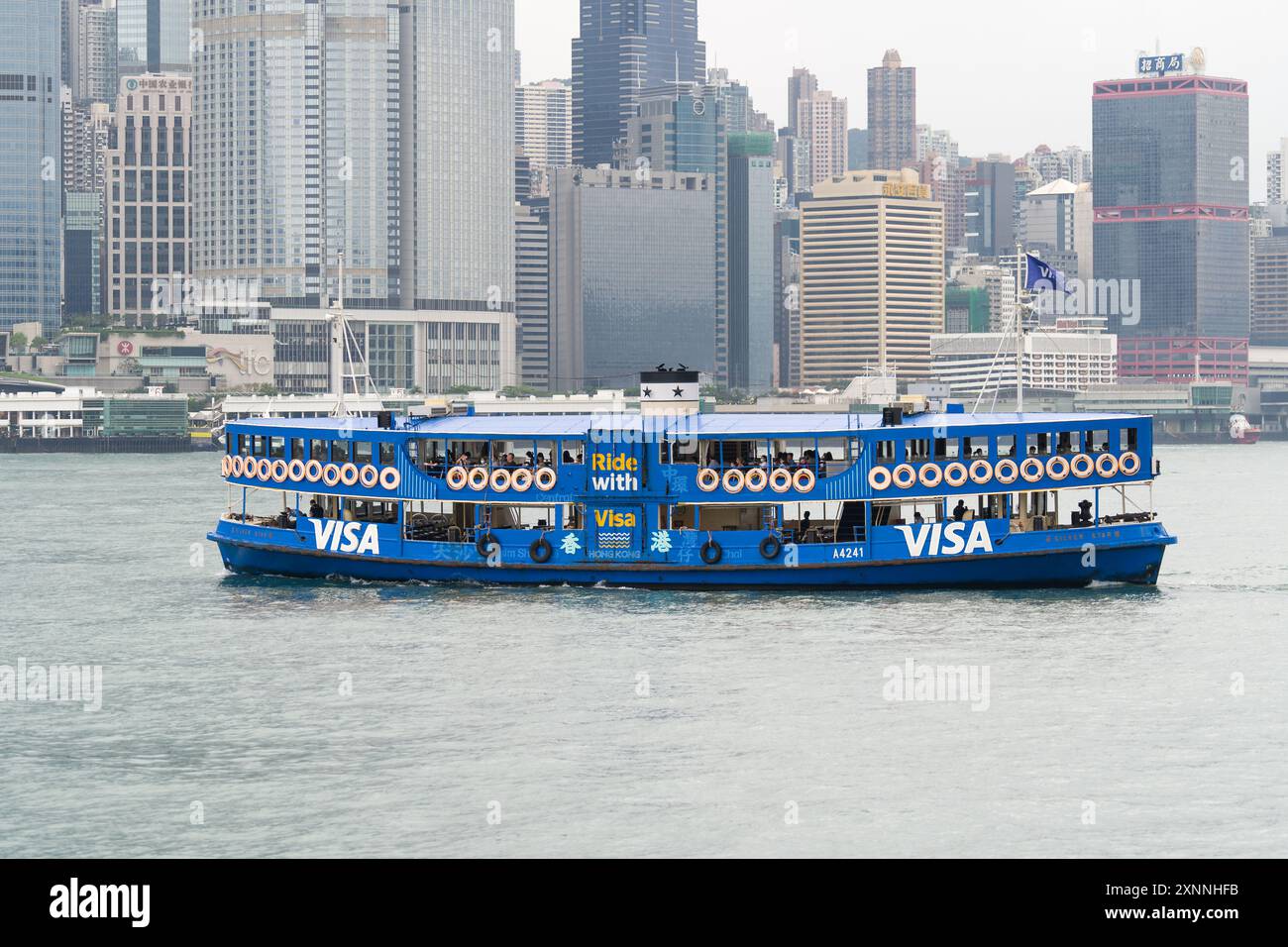 Traghetto Blue Star con logo Visa, navigando nel porto di Victoria durante il giorno. Hong Kong - 26 maggio 2024 Foto Stock