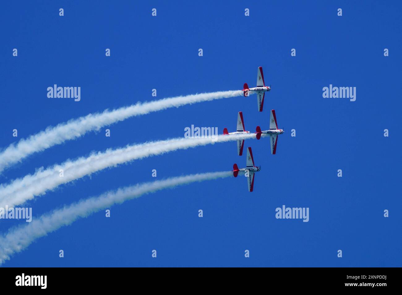 Symbolbild Kunstflugshow, vier Flugzeuge, formazione, Kondensstreifen, blauer Himmel, präzises Fliegen, rote und weiße Lackierung, beeindruckende Flugmanöver, Luftakrobatik, aufregendes Spektakel, Flugshow, lavoro di squadra, Luftfahrtenthusiasten, Flugkünste, Dyische Vorführung, hoher Schwierigkeitsgrad, öffentliche Veranstaltung, Freizeitaktivität, Pilotenfähigkeiten, Aeroshell *** spettacolo acrobatico con immagini simboliche, quattro aerei, formazione, contraglie, cielo blu, volo preciso, livrea rossa e bianca, impressionanti manovre di volo, acrobazie aeree, spettacolo emozionante, spettacolo aereo, lavoro di squadra, aviazione enthus Foto Stock