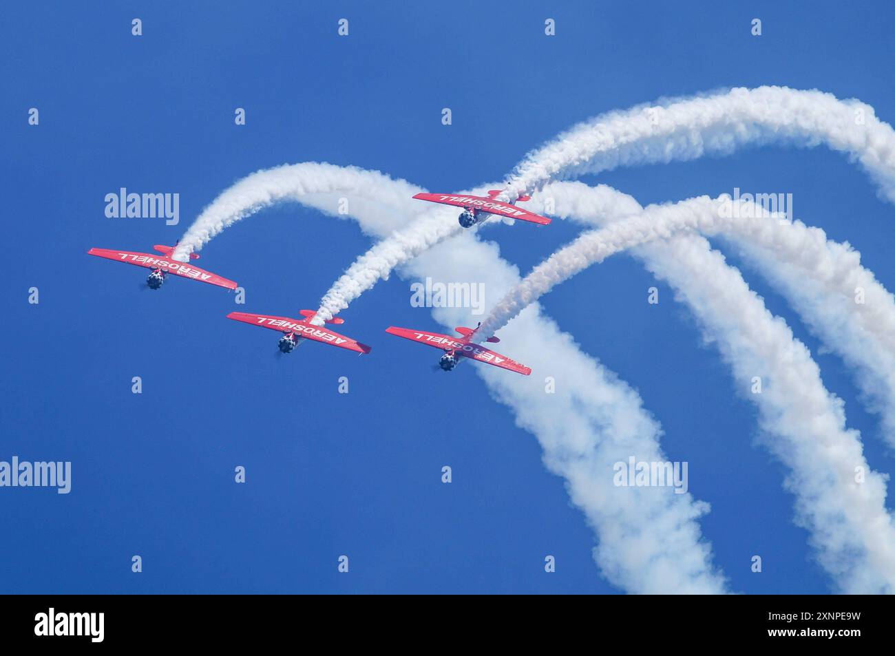 Symbolbild Kunstflugshow, vier Flugzeuge, formazione, Kondensstreifen, blauer Himmel, präzises Fliegen, rote und weiße Lackierung, beeindruckende Flugmanöver, Luftakrobatik, aufregendes Spektakel, Flugshow, lavoro di squadra, Luftfahrtenthusiasten, Flugkünste, Dyische Vorführung, hoher Schwierigkeitsgrad, öffentliche Veranstaltung, Freizeitaktivität, Pilotenfähigkeiten, Aeroshell *** spettacolo acrobatico con immagini simboliche, quattro aerei, formazione, contraglie, cielo blu, volo preciso, livrea rossa e bianca, impressionanti manovre di volo, acrobazie aeree, spettacolo emozionante, spettacolo aereo, lavoro di squadra, aviazione enthus Foto Stock