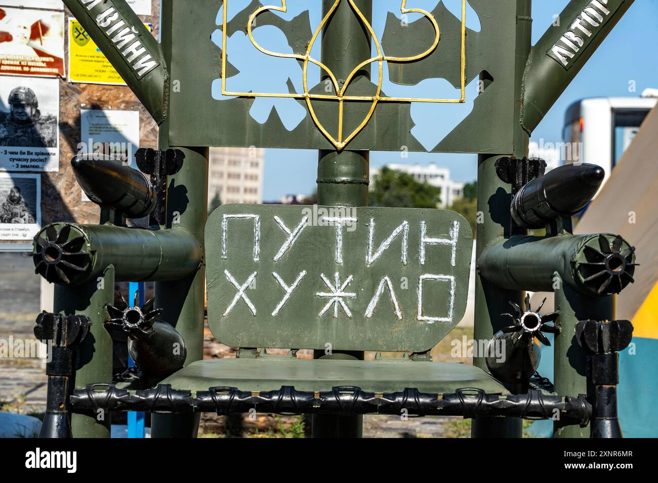 Questa installazione artistica, simile a un trono, è fatta dai resti di proiettili e bombe russe utilizzate negli attacchi contro l'Ucraina. Situato nel centro della città di Charkiv, Ucraina, visto venerdì 2 agosto 2024, questo pezzo è un potente simbolo di resistenza e sfida. L'uso di detriti militari per creare una sedia sottolinea la trasformazione degli strumenti di guerra in un'espressione di resilienza. L'iscrizione in russo, "Путин х**ло", si traduce in "Putin è un d*ckhead", un sentimento ampiamente condiviso tra gli ucraini che hanno sopportato la devastazione del conflitto in corso. (Foto VX/Vudi Foto Stock