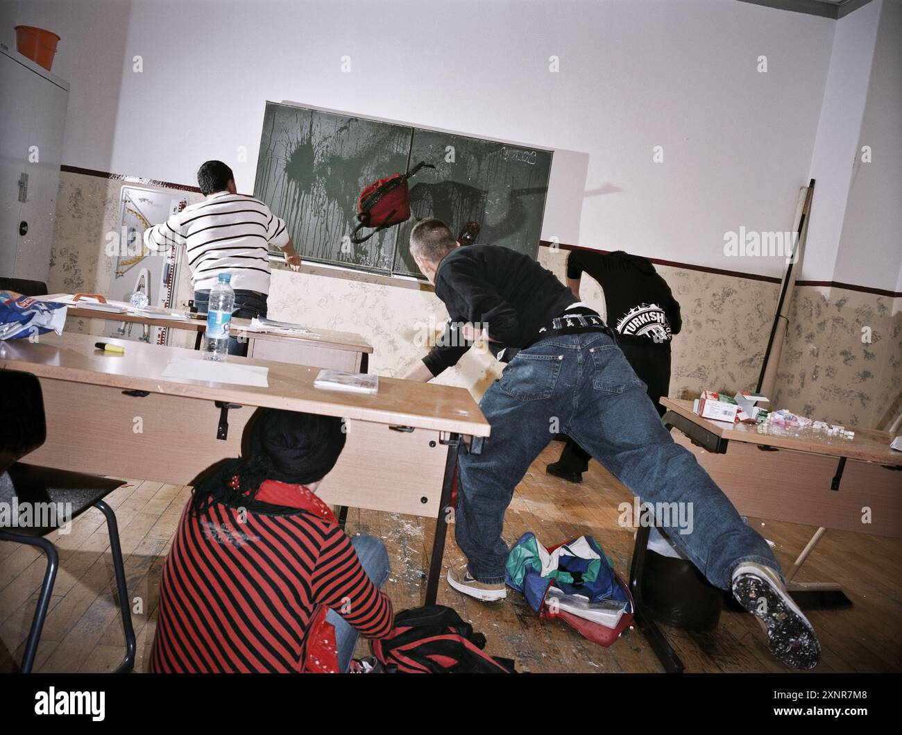 Rievocazione di una scena tumultuosa in una classe che mostra alterchi fisici, danni alle proprietà e caos. La foto acquisisce l'intensità e il diso Foto Stock