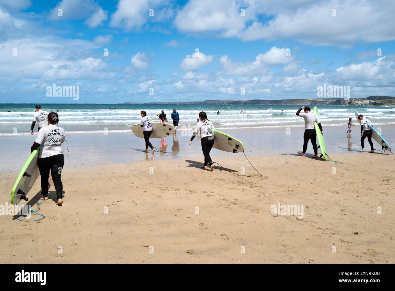 Un gruppo di principianti di surf che iniziano una lezione di surf con la scuola di surf SSS a Towan Beach a Newquay in Cornovaglia nel Regno Unito. Foto Stock
